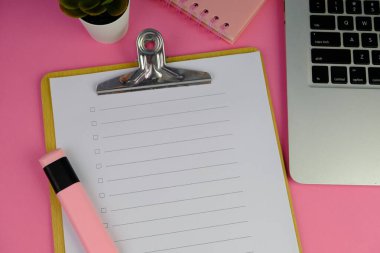 Günlük, kalem, dizüstü bilgisayar, kahve fincanı ve gri arka planda dekor bitkisi olan boş bir çalışma alanı. Üst manzara, düz yatış. kontrol listesi konsepti