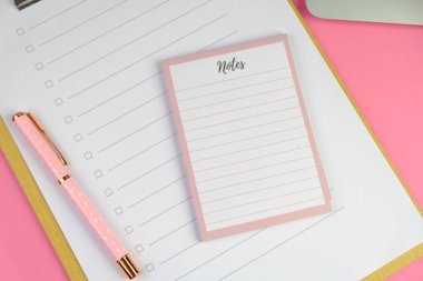 Günlük, kalem, dizüstü bilgisayar, kahve fincanı ve gri arka planda dekor bitkisi olan boş bir çalışma alanı. Üst manzara, düz yatış. kontrol listesi konsepti