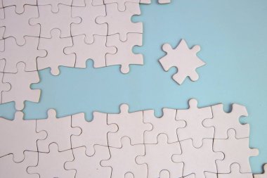 Bir metin şablonu için kayıp bulmacalı beyaz yapboz. Mavi arkaplanda izole edilmiş fotoğrafın üzerinde