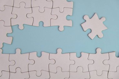 Metin şablonu için eksik parçaları olan boş beyaz bulmaca. Yeşil arkaplanda izole edilmiş fotoğrafın üzerinde