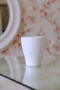 Pembe çiçek duvar kağıdıyla pembe ve yeşil bir temanın üst görüntüsü ve mesajınız için kısmen görünür beyaz bardak seti, aşk, yumuşak, kadınsı ve romantik konsept.