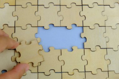 Metin şablonu için eksik parçaları olan boş beyaz bulmaca. Yeşil arkaplanda izole edilmiş fotoğrafın üzerinde