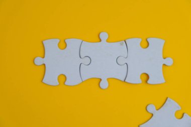 Metin şablonu için eksik parçaları olan boş beyaz bulmaca. Yeşil arkaplanda izole edilmiş fotoğrafın üzerinde