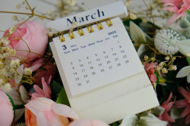 Ofis arka planında Mart 2025 için aylık masa takvimi. 