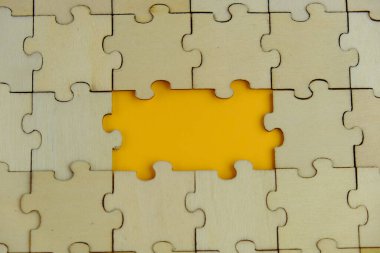 Tahta yapboz ve kayıp bir yapboz. İzole edilmiş arkaplanda izole edilmiş fotoğrafın üzerinde