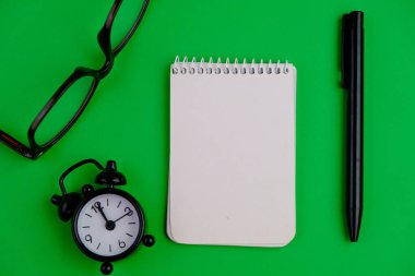 Sade bir arka planda, not defteri olan düz bir iş yeri. Eğitim, iş ve ofis kavramı. 