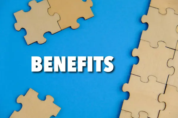 Laptopun yanındaki kahverengi zarfın içindeki düz kartta BENEFITS 'in metni. iş kavramı.