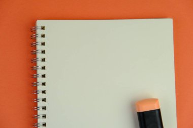 Sade bir arka planda, not defteri olan düz bir iş yeri. Eğitim, iş ve ofis kavramı. 