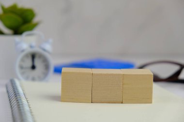 Metin alanı için boş bir tahta küp düzlüğü. Mavi arka planda metin alanı olan eğitici ve finansal kavram. ofis araçlarıyla çevrili.