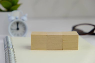 Metin alanı için boş bir tahta küp düzlüğü. Mavi arka planda metin alanı olan eğitici ve finansal kavram. ofis araçlarıyla çevrili.