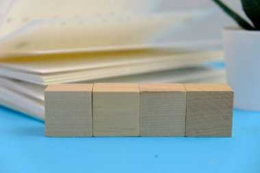 Metin alanı için boş bir tahta küp düzlüğü. Mavi arka planda metin alanı olan eğitici ve finansal kavram. ofis araçlarıyla çevrili.