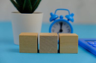 Metin alanı için boş bir tahta küp düzlüğü. Mavi arka planda metin alanı olan eğitici ve finansal kavram. ofis araçlarıyla çevrili.