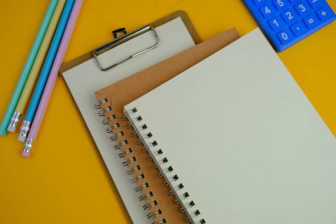 Sade bir arka planda, not defteri olan düz bir iş yeri. Eğitim, iş ve ofis kavramı. 