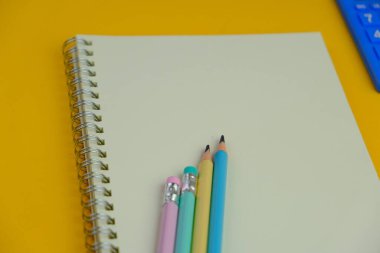 Sade bir arka planda, not defteri olan düz bir iş yeri. Eğitim, iş ve ofis kavramı. 