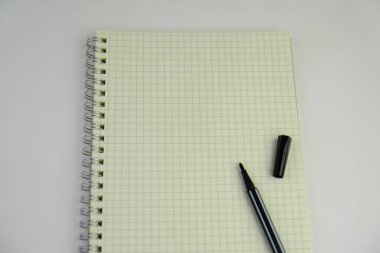 Sade bir arka planda, not defteri olan düz bir iş yeri. Eğitim, iş ve ofis kavramı. 