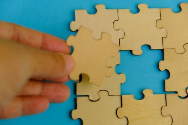 Tahta yapboz ve kayıp bir yapboz. İzole edilmiş arkaplanda izole edilmiş fotoğrafın üzerinde