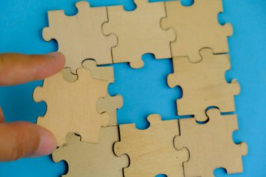 Tahta yapboz ve kayıp bir yapboz. İzole edilmiş arkaplanda izole edilmiş fotoğrafın üzerinde