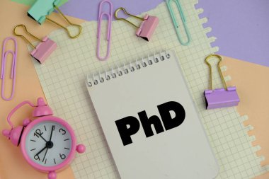 Not defterlerinin, hesap makinesinin, siyah arkaplandaki bir kalemin yanındaki tahta olmayan küplerin metni.