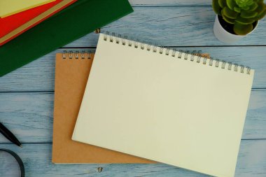 Metin alanı için boş bir not defterinin düz uzantısı. Mavi arka planda metin alanı olan eğitici ve finansal kavram. ofis araçlarıyla çevrili.