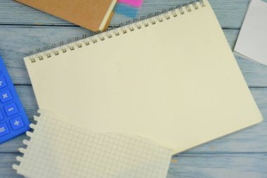 Metin alanı için boş bir not defterinin düz uzantısı. Mavi arka planda metin alanı olan eğitici ve finansal kavram. ofis araçlarıyla çevrili.
