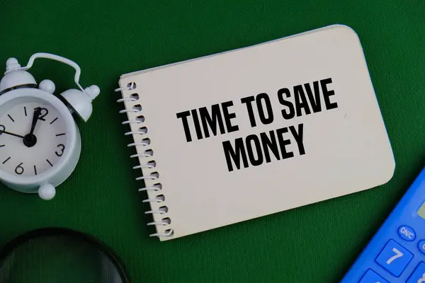 Beyaz alarm saati, hesap makinesi ve yeşil arkaplanda para tasarrufu yapmak için mesaj zamanı olan not defteri 