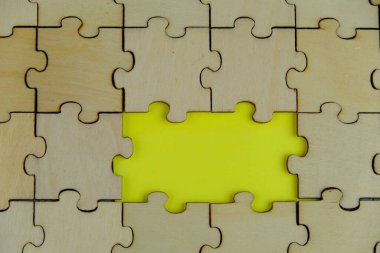 Tahta yapboz ve kayıp bir yapboz. İzole edilmiş arkaplanda izole edilmiş fotoğrafın üzerinde