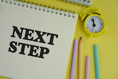 Yeşil arkaplan üzerine NEXT STEP metin bir iş, eğitim kavramı olarak not defteri. 
