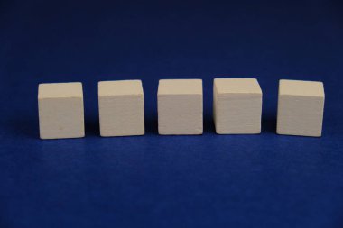 Metin alanı için boş bir tahta küp düzlüğü. Mavi arkaplanda metin alanı olan eğitim ve finans kavramı. 