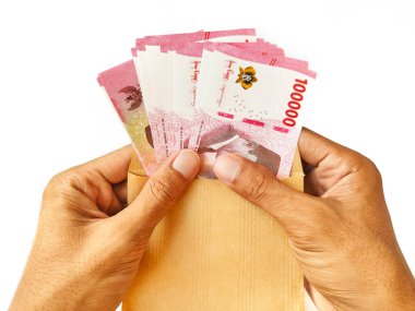 Zarfta Endonezya banknotları tutan adam.