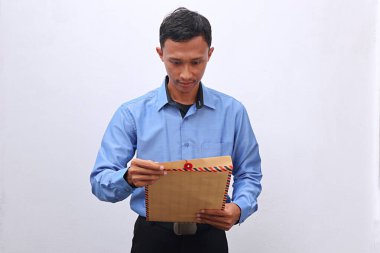 Genç bir Asyalı iş görüşmesine hazır bir özgeçmiş içeren kahverengi bir zarf hazırlıyor.