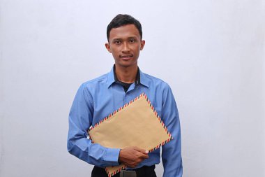 Genç Asyalı bir adam içinde CV olan kahverengi bir zarfı iş görüşmesine hazır tutuyor.