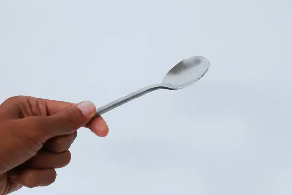 Kore kaşığı tutan bir el.