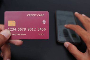 Sol el kredi kartı ve sağ el el, Market 'i el telefonuna kaydırıyor. Çevrimiçi alışveriş kavramı.