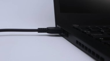 Laptop beyaz arkaplanda şarj ediliyor