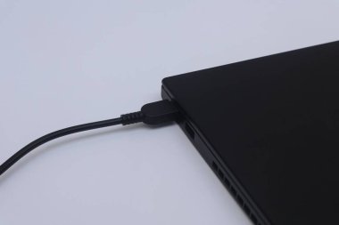 Laptop beyaz arkaplanda şarj ediliyor