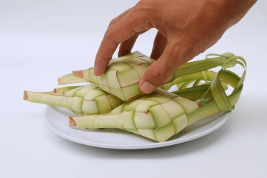 El ketupatı beyaz bir tabakta alır. Kurban Bayramı 'nda geleneksel Endonezya yemekleri                          