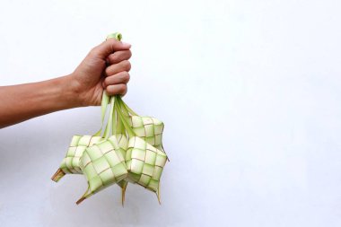 Beyaz arka planda ketupa dokunan eller. Kurban Bayramı 'nda geleneksel Endonezya yemekleri                         