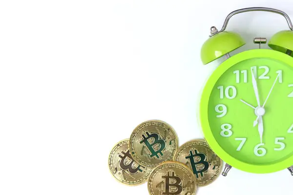 Beyaz arkaplanda bitcoins ve alarm saati                      