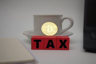 Kırmızı blok bir fincan kahve ve bitcoin 'in önünde vergi olduğunu söylüyor.