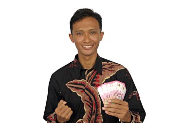 Asyalı bir adam mutlu bir ifadeyle bir sürü rupiah parası tutar.