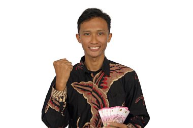 Asyalı bir adam mutlu bir ifadeyle bir sürü rupiah parası tutar.