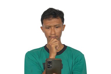 Cep telefonu tutan Asyalı bir adam cep telefonu ekranına bakarken ciddi bir ifade sergiliyor..