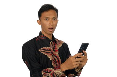 Elinde akıllı telefon tutan Asyalı bir adam şaşırmış bir ifadeyle