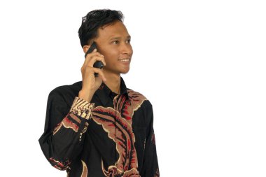 Bir telefon görüşmesi yaparken gülümseyen Asyalı adam.