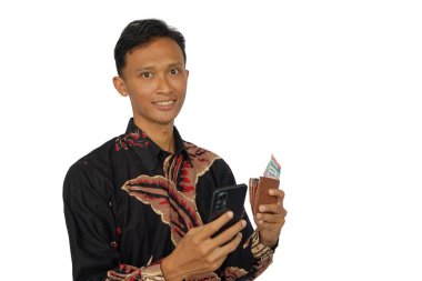 İçinde para olan bir cüzdan ve mutlu bir ifadeyle cep telefonu tutan Asyalı bir adam.