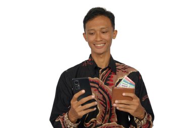 İçinde para olan bir cüzdan ve mutlu bir ifadeyle cep telefonu tutan Asyalı bir adam.