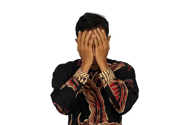 Asyalı adamın yüzü kameraya dönük, stresli bir ifade.