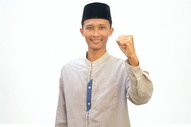 Beyaz gömlekli Asyalı Müslüman adam beyaz arka planda izole edilmiş kameraya gülümsüyor.