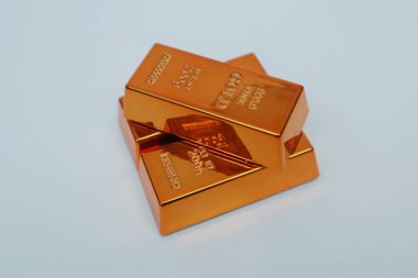 Beyaz arka planda parlayan altın külçeleri