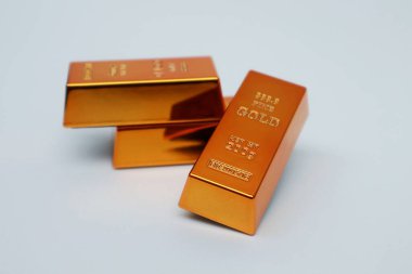 Beyaz arka planda parlayan altın külçeleri